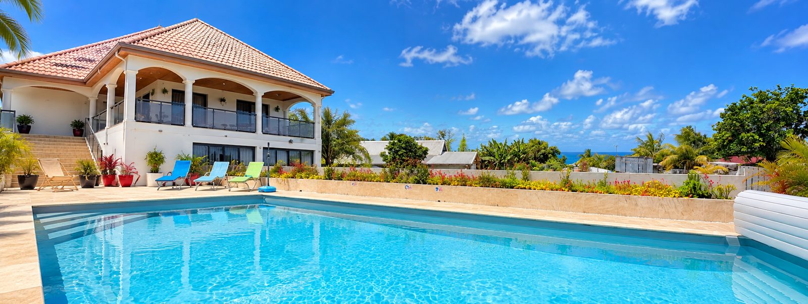 La villa et sa piscine, ciel bleu et océan à l'horizon